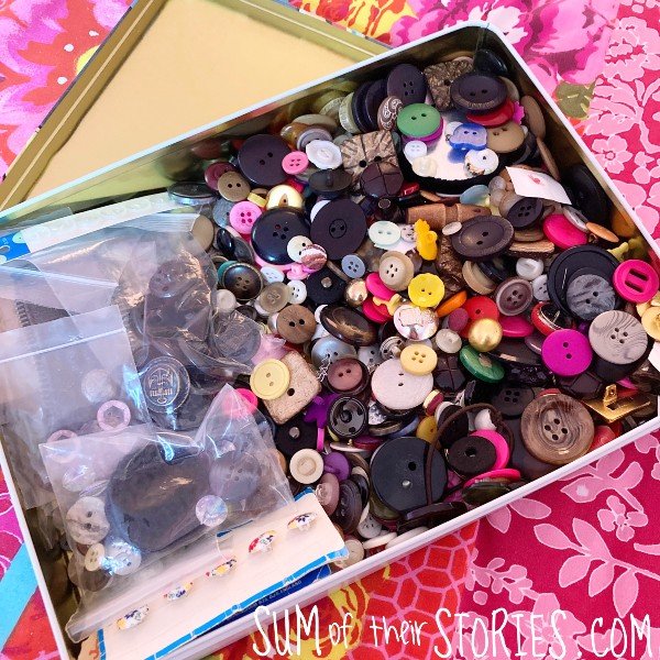 An old rectangular tin full of buttons of all shapes, sizes and colours