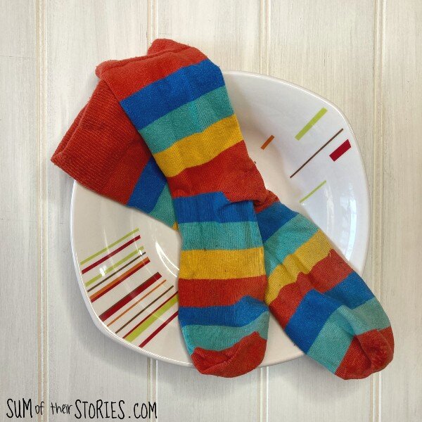 a pair of rainbow socks in a bowl ready for upcycling