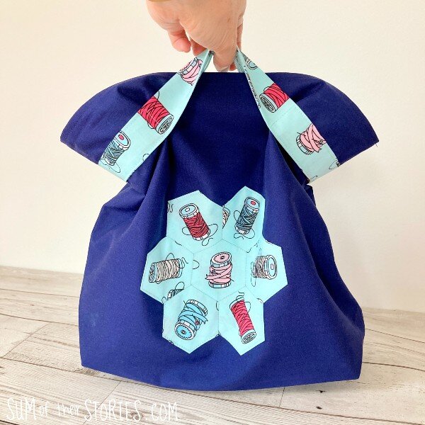 A small blue handmade bag with EPP hexagon patchwork motif