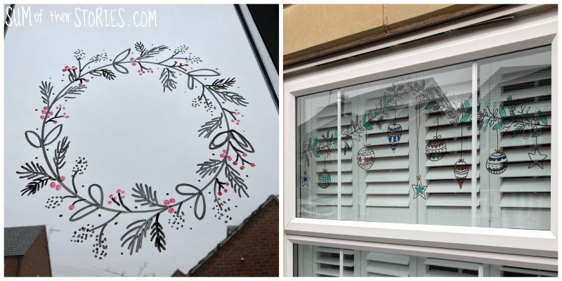 2 windows with christmas wreaths drawn on them with wipe board markers