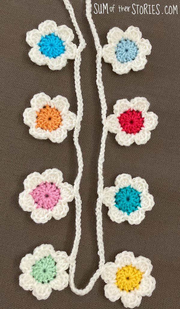 a crochet flower garland with colourful flower centres