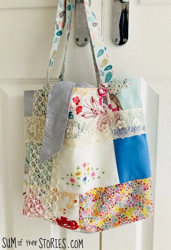 A patchwork and lace tote bag hanging on a door handle