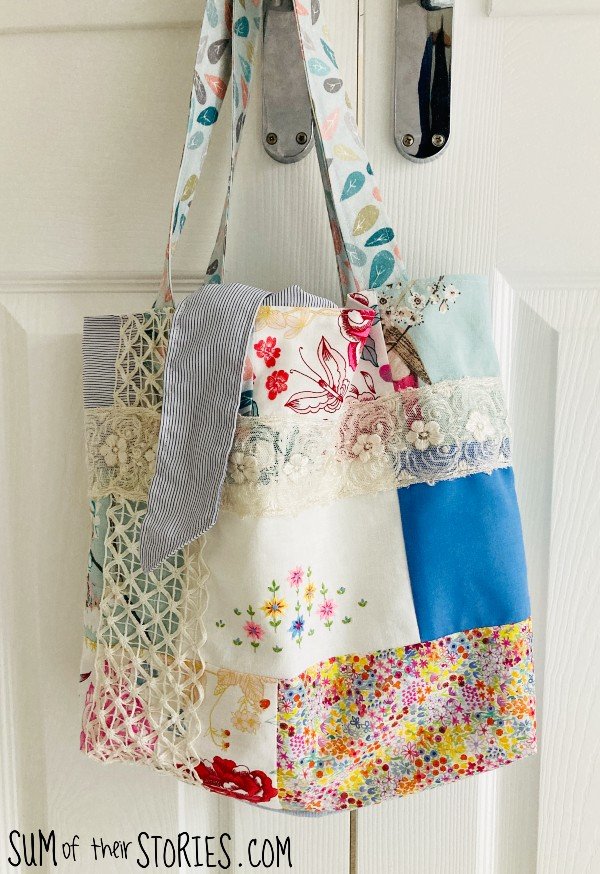 A patchwork and lace tote bag hanging on a door handle