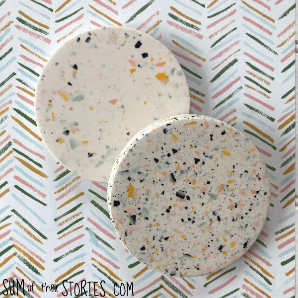 2 coasters with a terrazzo effect on a arrow patterned background