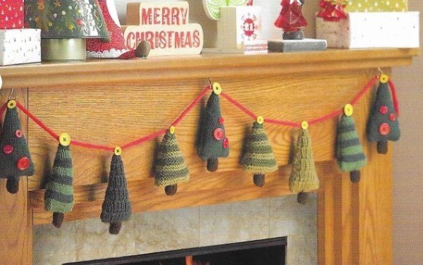 A knitted Christmas tree garland on a fireplace