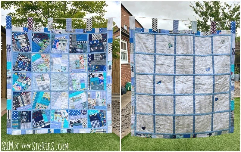 scrappy blue quilt hanging from a washing line