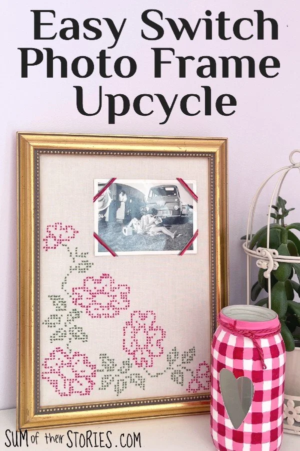 upcycled photo frame with an embroidered fabric insert and corners so a photo can be switched easily. The frame is propped against a wall with a vase and plant to the right side