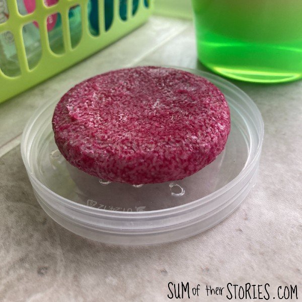 a soap dish upcycled from pringle lids with a pink shampoo bar on it