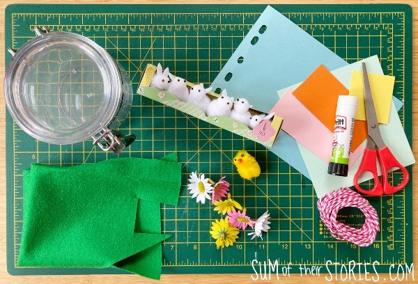 a pile of craft supplies needed to make a spring terrarium in a jar