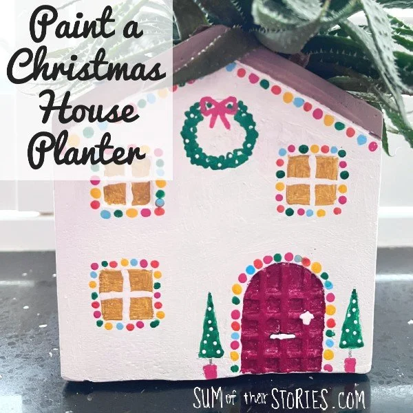 house shaped planted painted to look christmassy with trees and wreath and lights