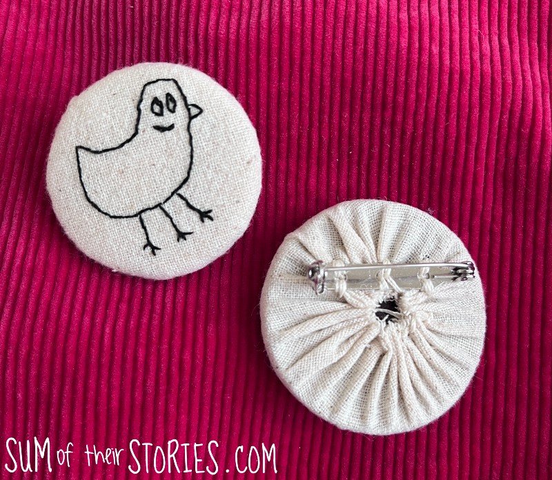 front and back of an embroidered badge with the duck drawing from the other bennet sister