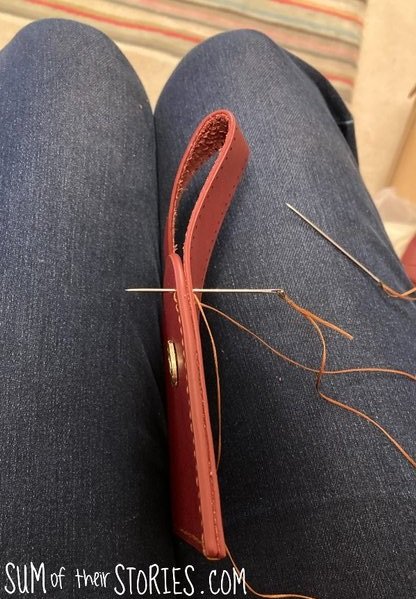 stitching a leather bag kit, the leather with a needle shown poking half way through