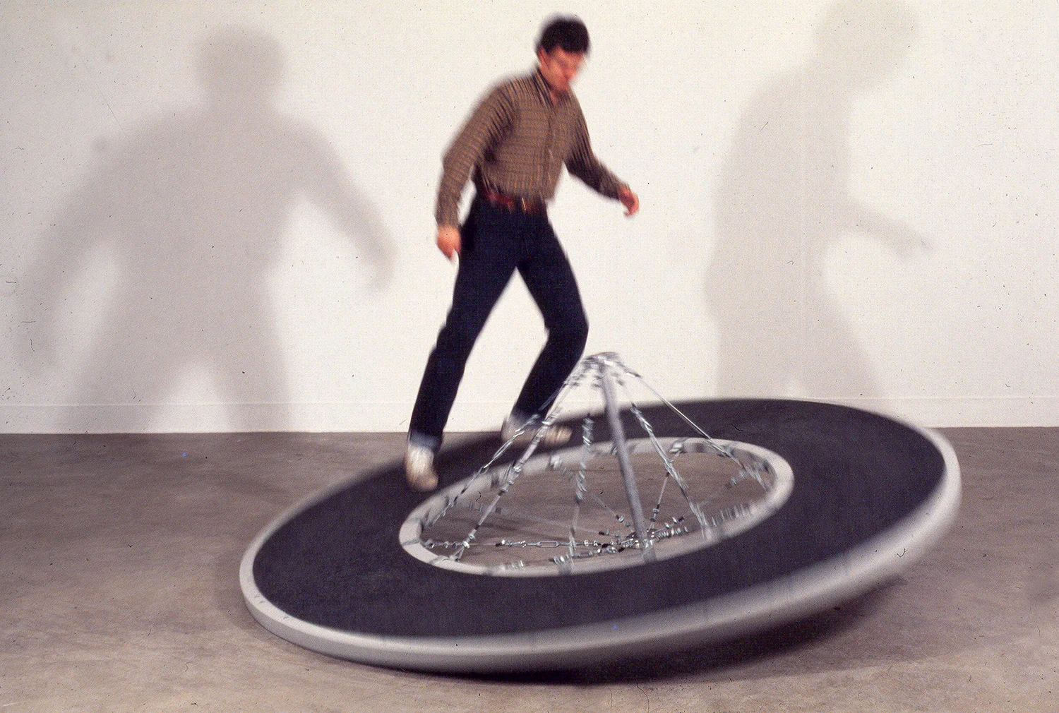 Off-Centered Consequences 1977 Wood/Aluminum 8’ diameter x 3’ Claremont Graduate School Gallery, Claremont, CA This piece was in my Thesis Show for my MFA. The experience was like climbing a hill and suddenly after crossing the invisible center line of gravity, the piece’s weight and momentum rotated to make you feel like you were being kicked off. Resistance then an unstable jolt, forcing one to compensate to stay upright in space. The piece weighed about 250 Lbs.