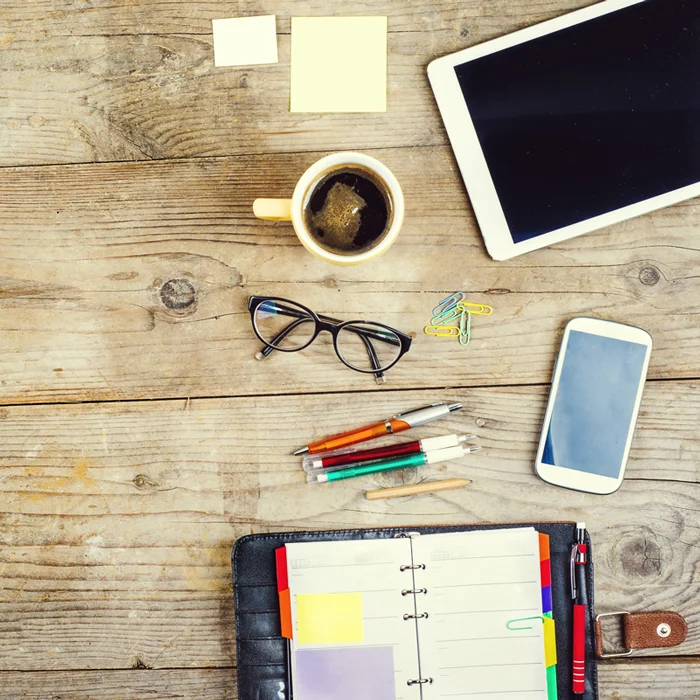 graphicstock-mix-of-office-supplies-and-gadgets-on-a-wooden-table-background-view-from-above_rCUmJrT-Z.jpg
