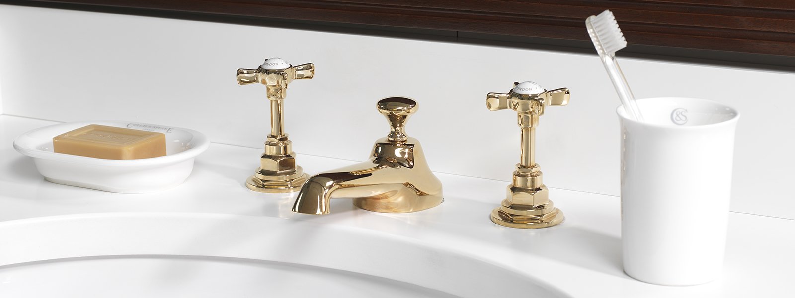 czech & speake deco widespread lav faucet with low spout and tall cross handles with porcelain inset in unlacquered brass - the ultimate guide to luxury plumbing by the delight of design