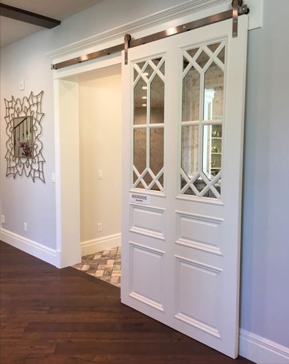 white sliding barn door with antiqued mirror and decorative mullion insert