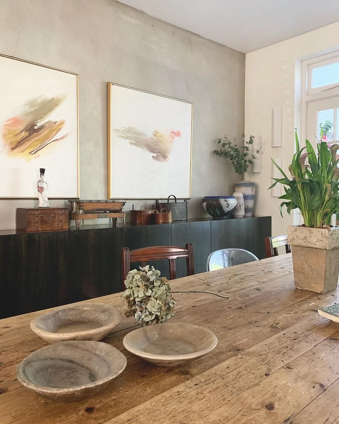 plaster wall earthy dining room stone bowl natural wood table rustic
