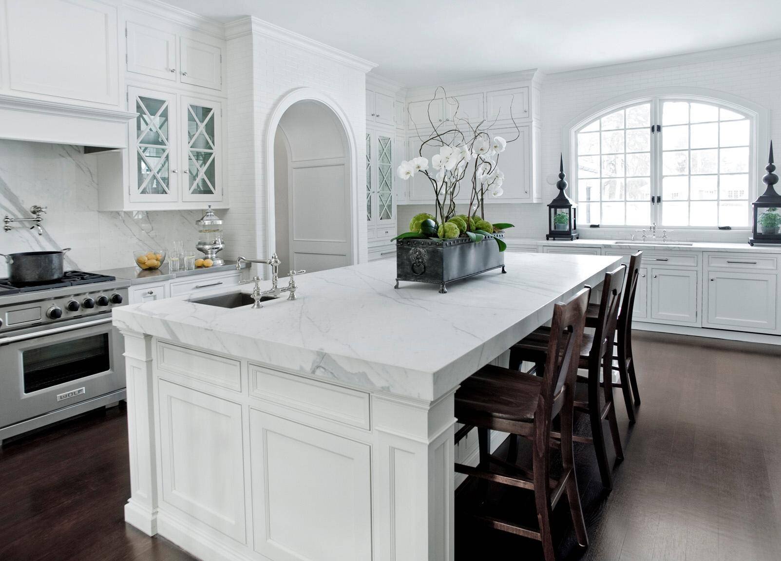 transitional kitchen white cabinets carrara marble counter dark wood floors glass
