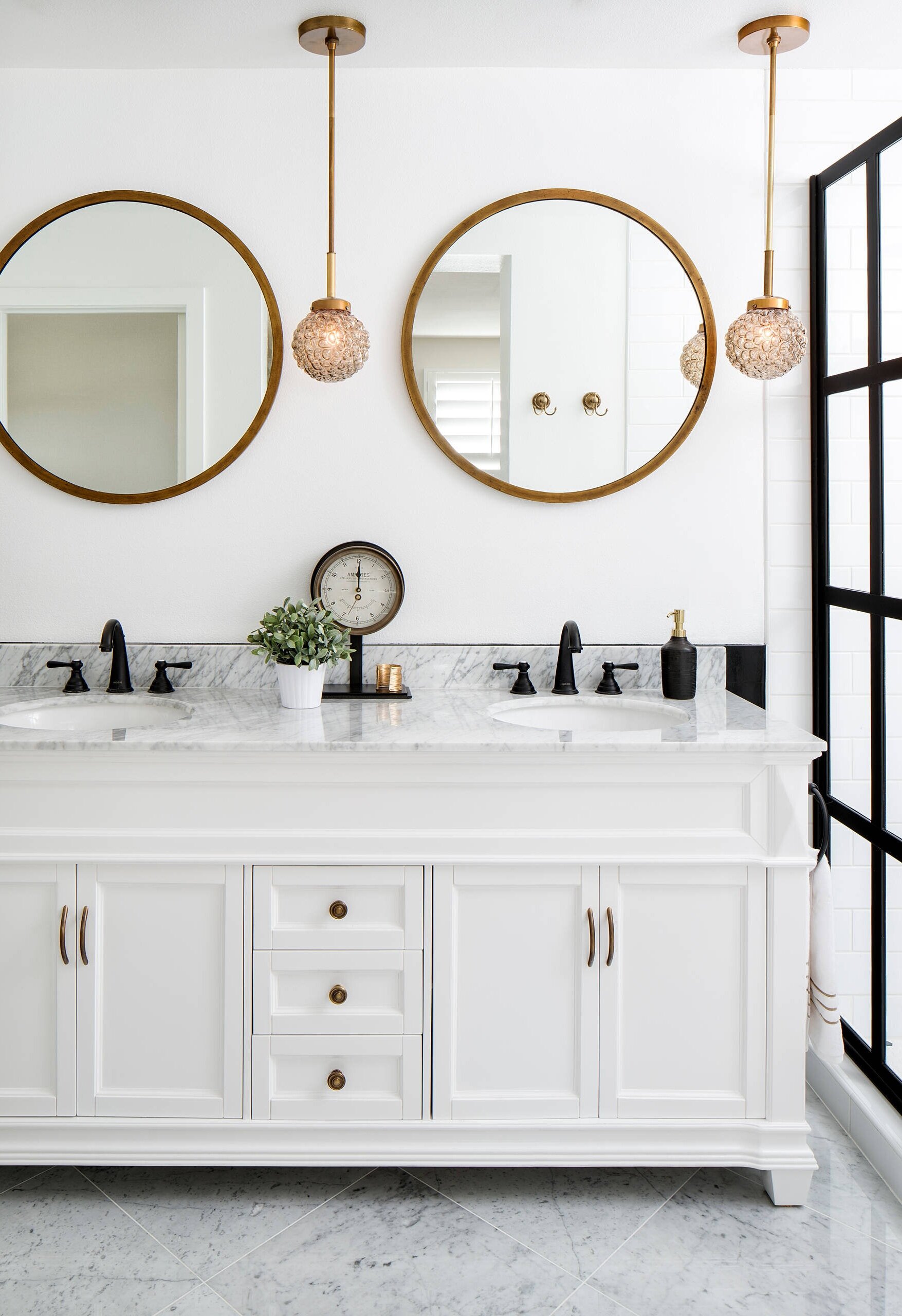 black gold bathroom double vanity white grid shower door carrara marble round mirror transitional modern