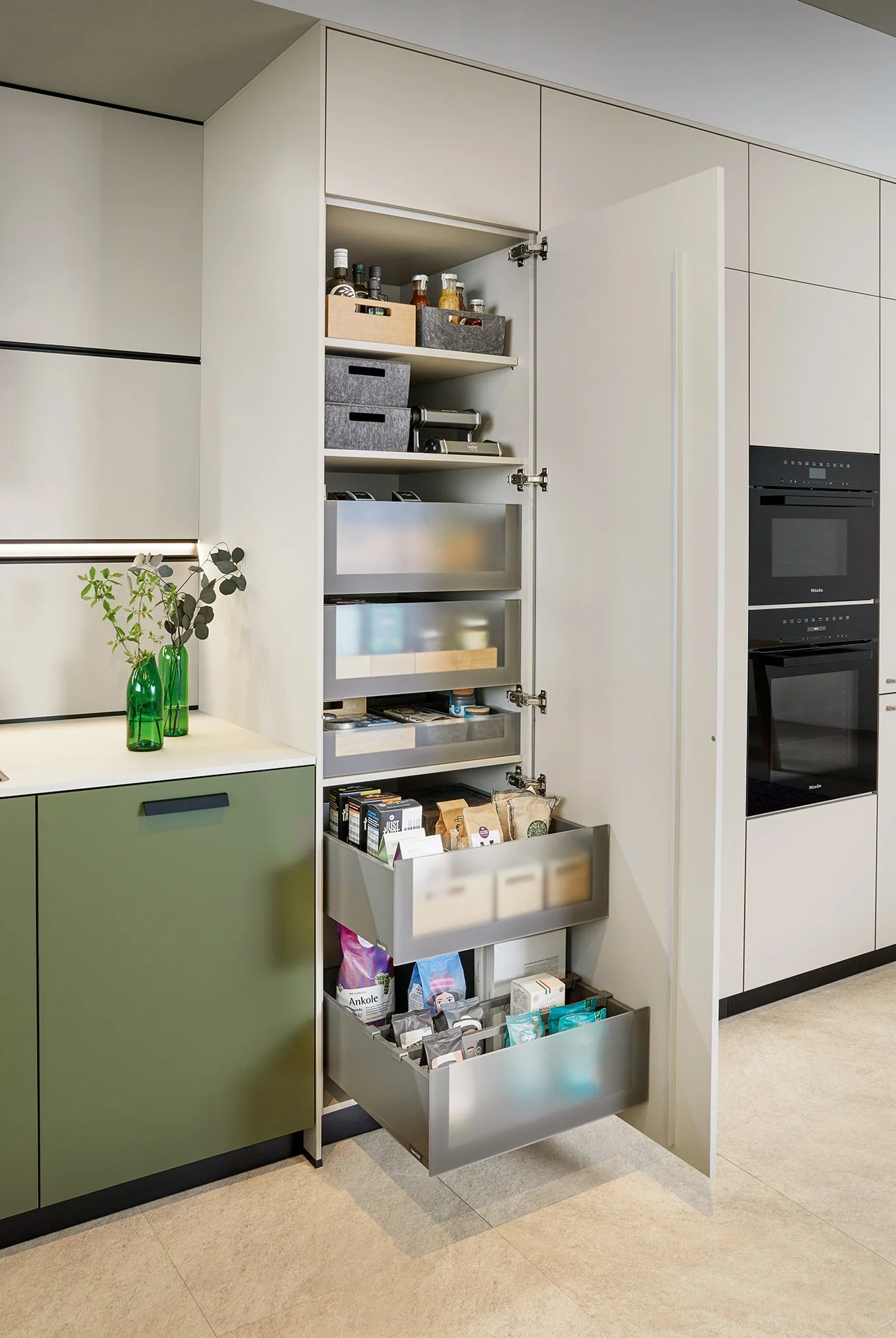 Kitchen pull-out shelving units for larder storage, adjacent to Green Linoleum kitchen and matt white cabinetry