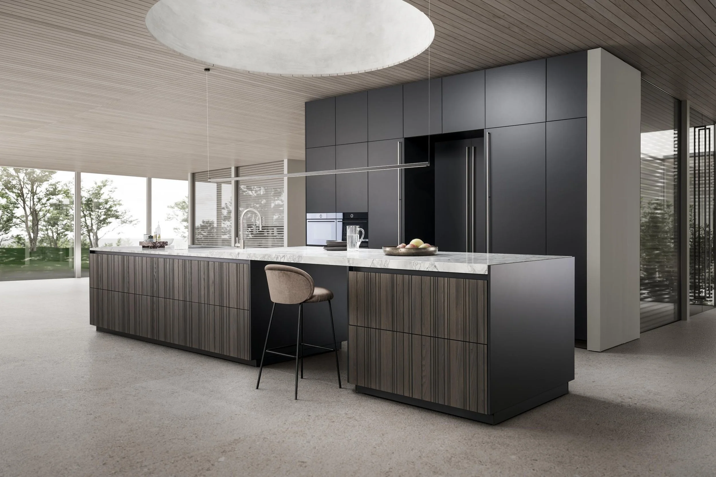 Modern LEICHT Bahia and Classic FS kitchen with a large island with a marble countertop, dark wooden lower cabinets, and tall dark grey cabinets. Floor-to-ceiling windows with views of trees.