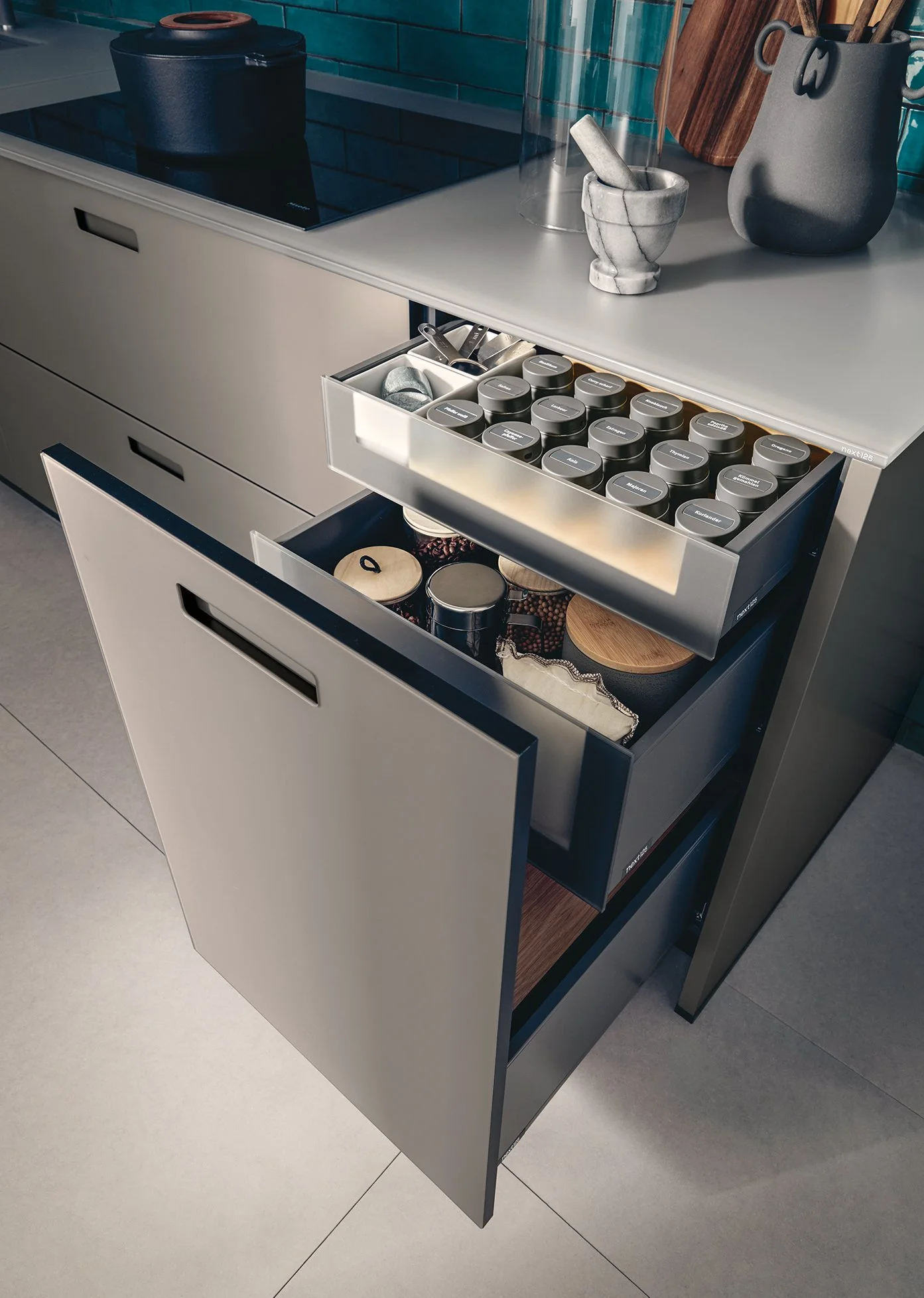 next125 glass fronted pull out base unit with internal drawer showing Blum legra box drawer accessory storage.