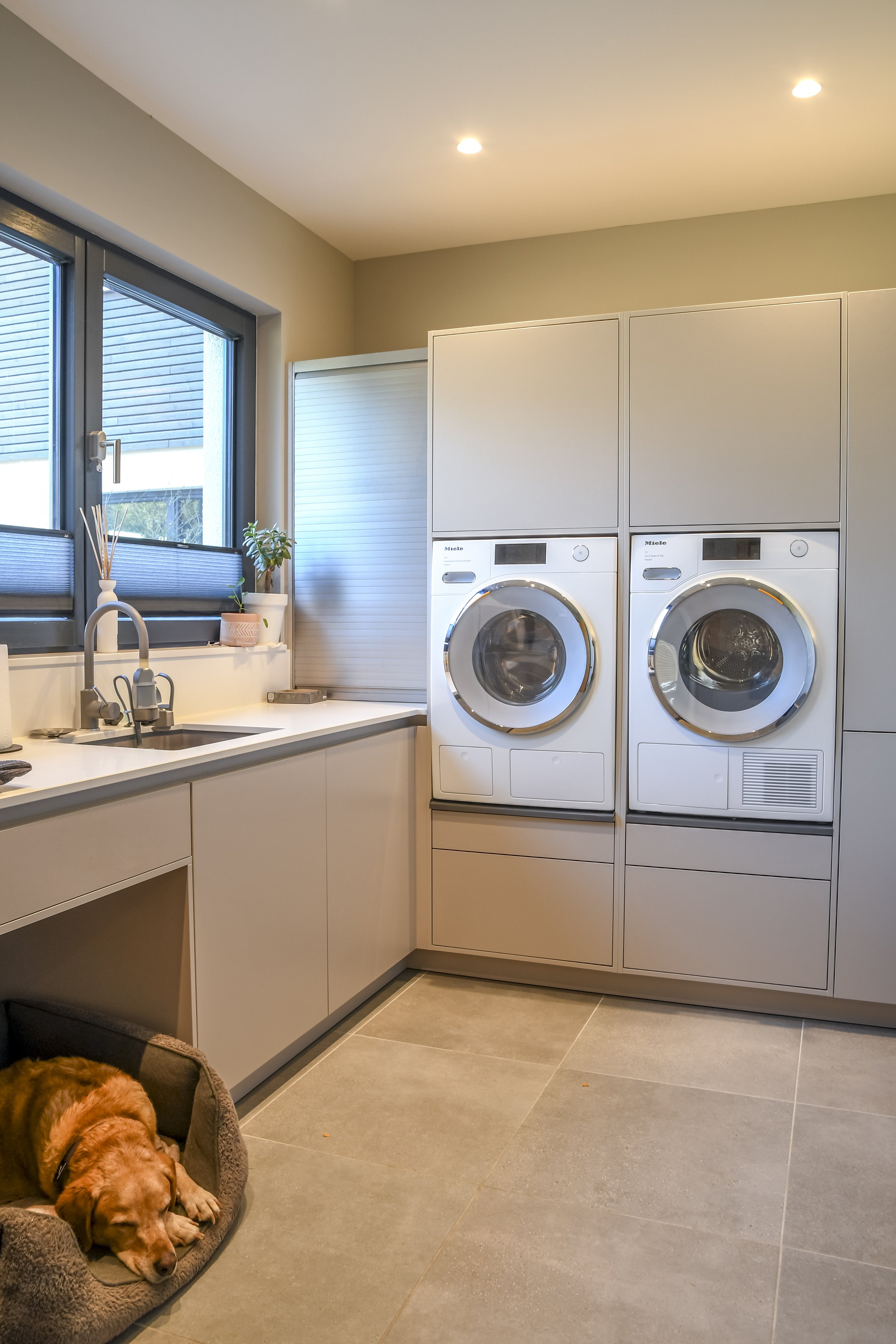 Luxury Norfolk utility room with Schuller storage solutions and raised height Miele Laundry appliances