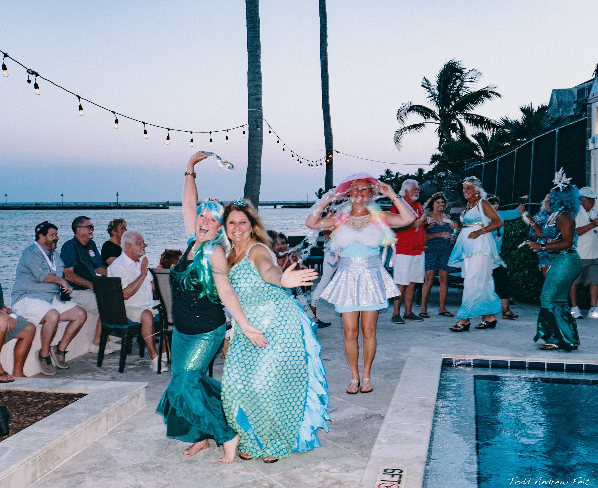 members in costume parade around the pool