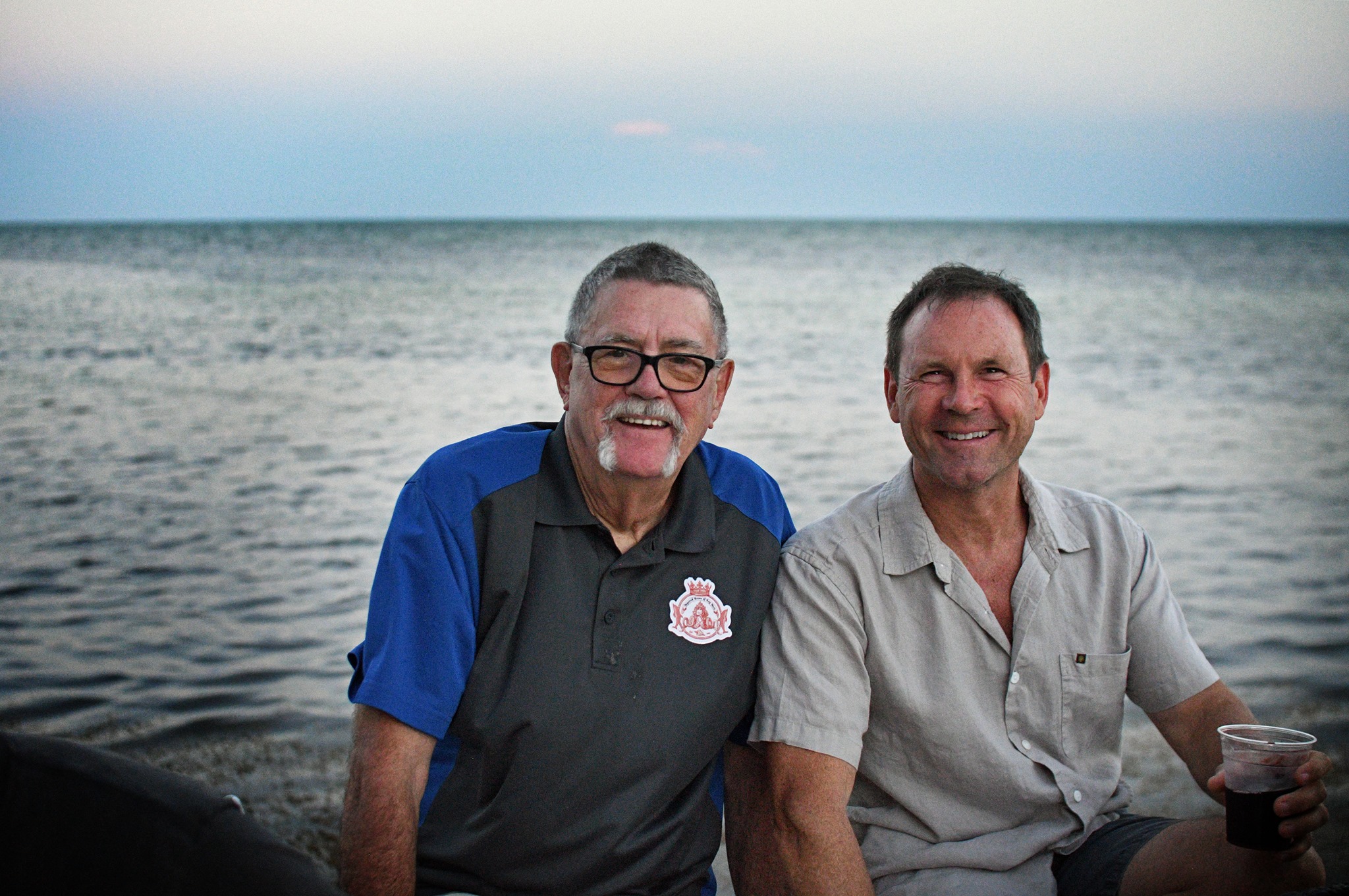 Larry Johnson & Todd German sitting by the ocean