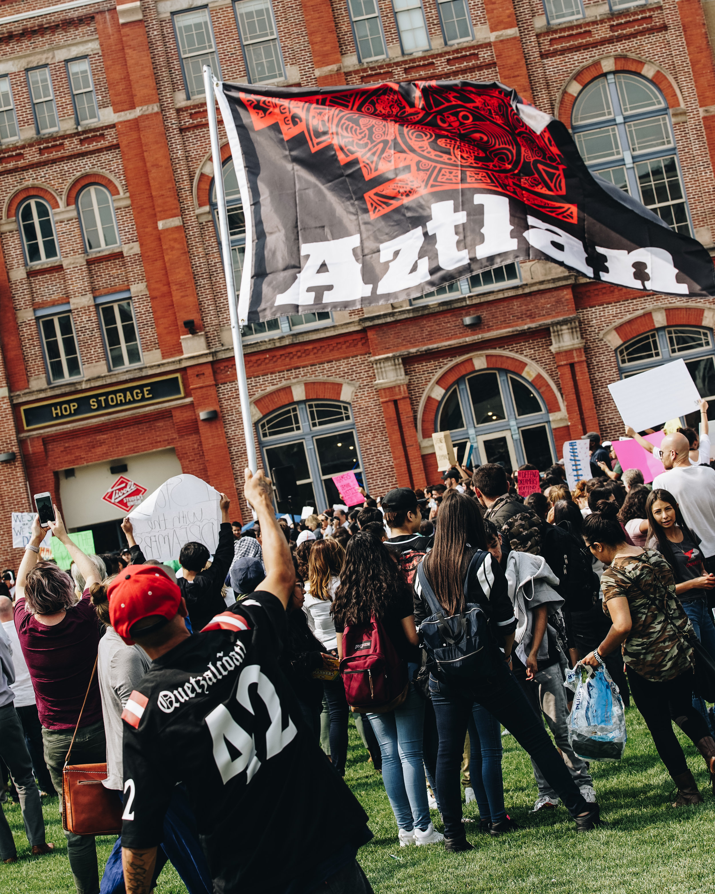 Another attendee raises the Aztlan flag.