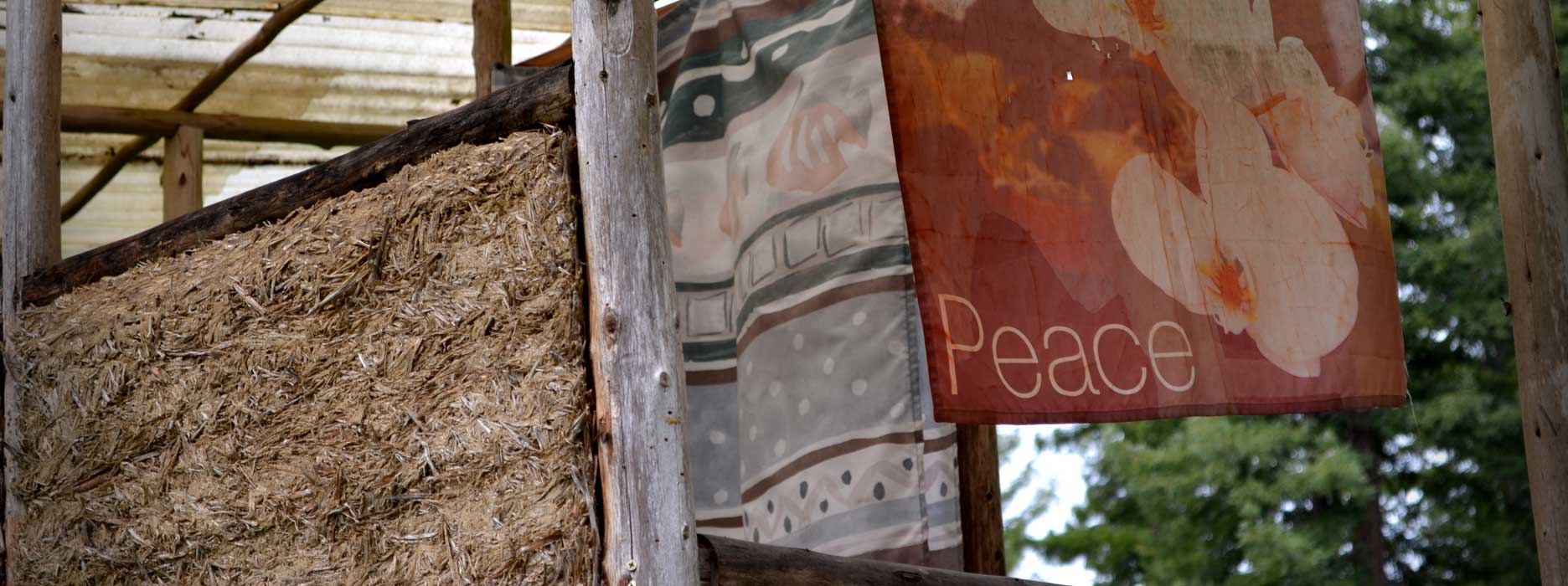 a peace banner hangs from an outdoor structure at Emerald Earth