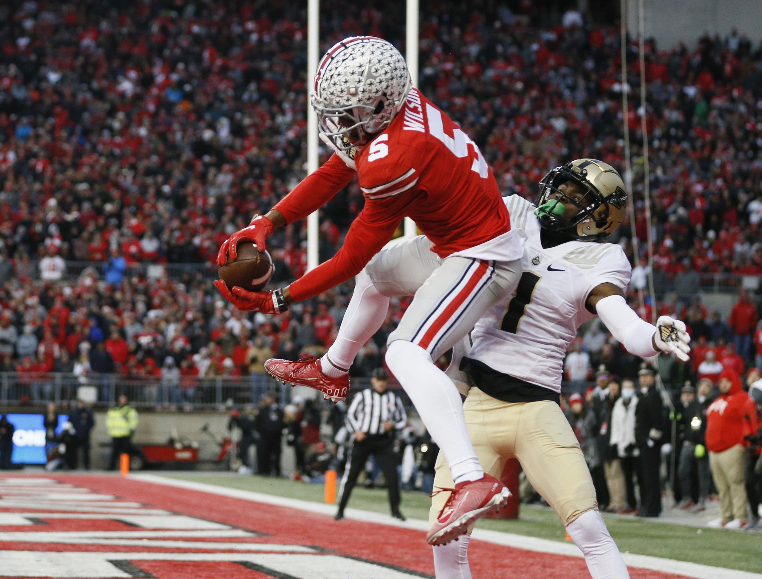 Ohio State Buckeyes wide receiver Garrett Wilson (5) catches touchdown pass in front of Purdue Boilermakers cornerback Dedrick Mackey (1) in the end zone during the second quarter of the NCAA Division 1 football game at Ohio Stadium in Columbus, Ohio