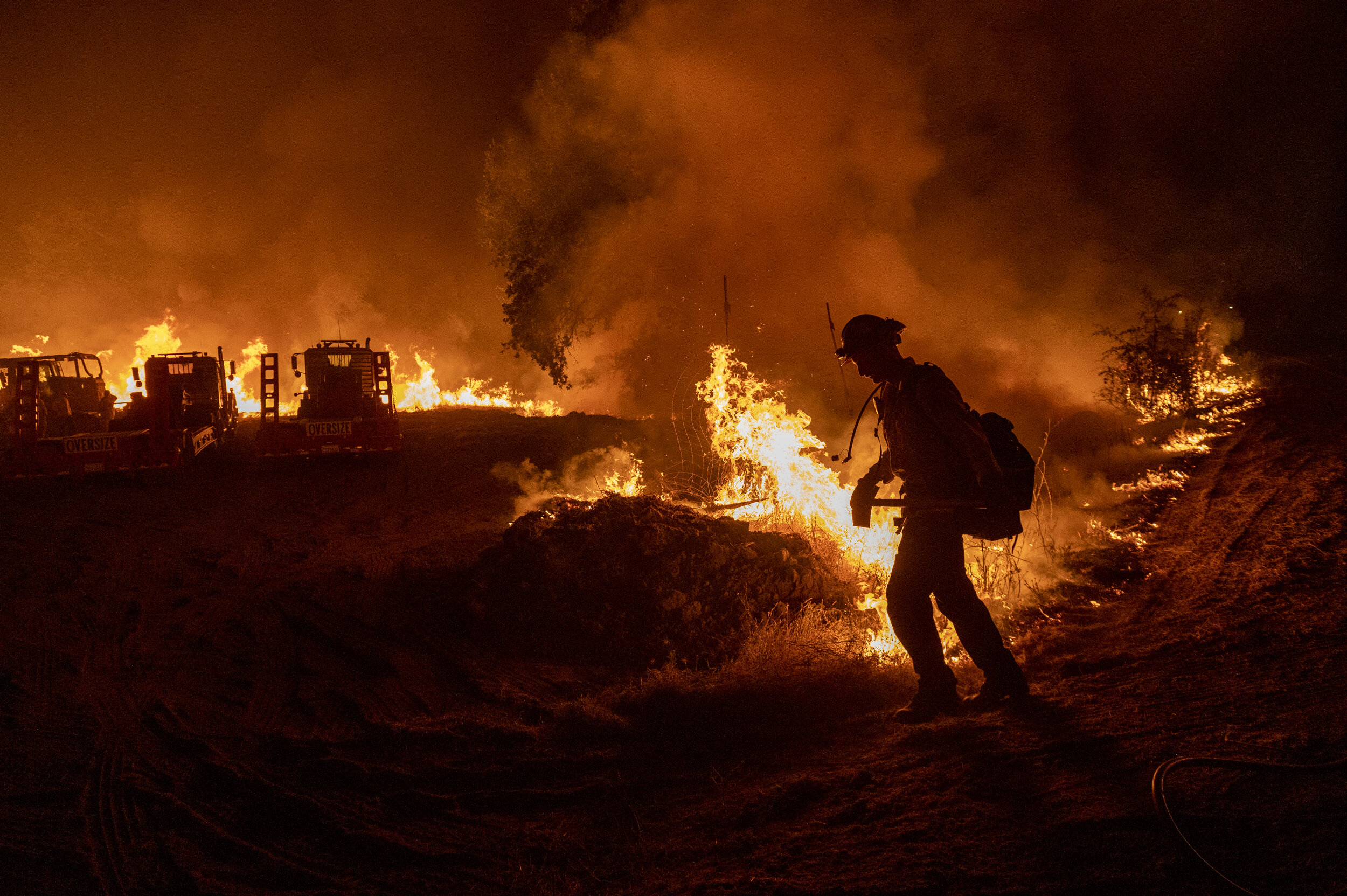  A firefighter heads back into the flames of the Sites fire while it burns in Stonyford, Calif., on Sunday, Aug. 3, 2020. 