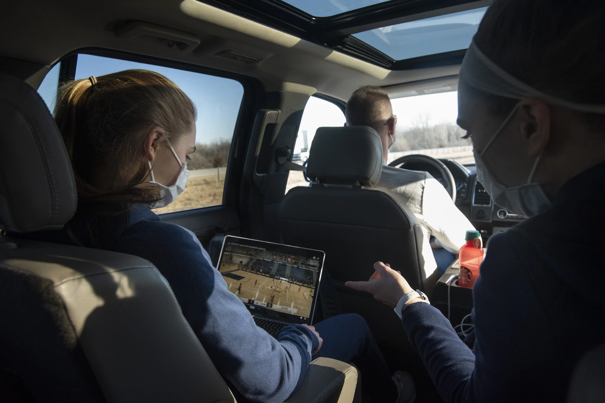  Kate Stemmer, left, and her older sister Ella prep for an away game against Monroe by watching film on the way to the game on Friday, March 5, 2021. Their parents drive them to every away game.  