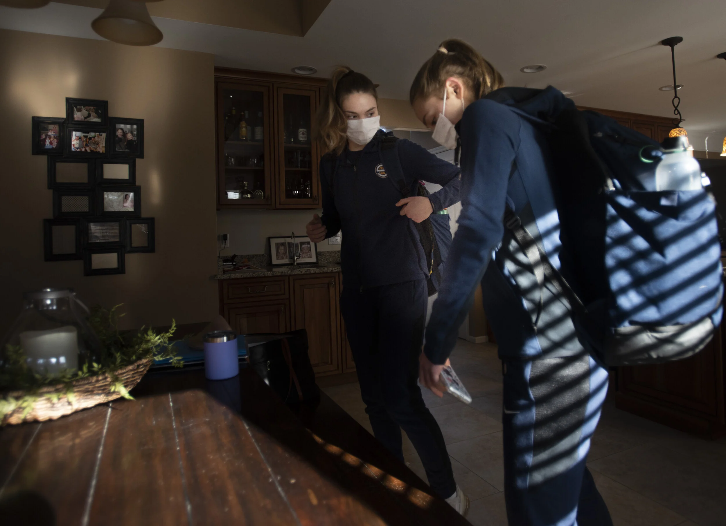  Ella and Kate pack up for a game in their home in Saline. 
