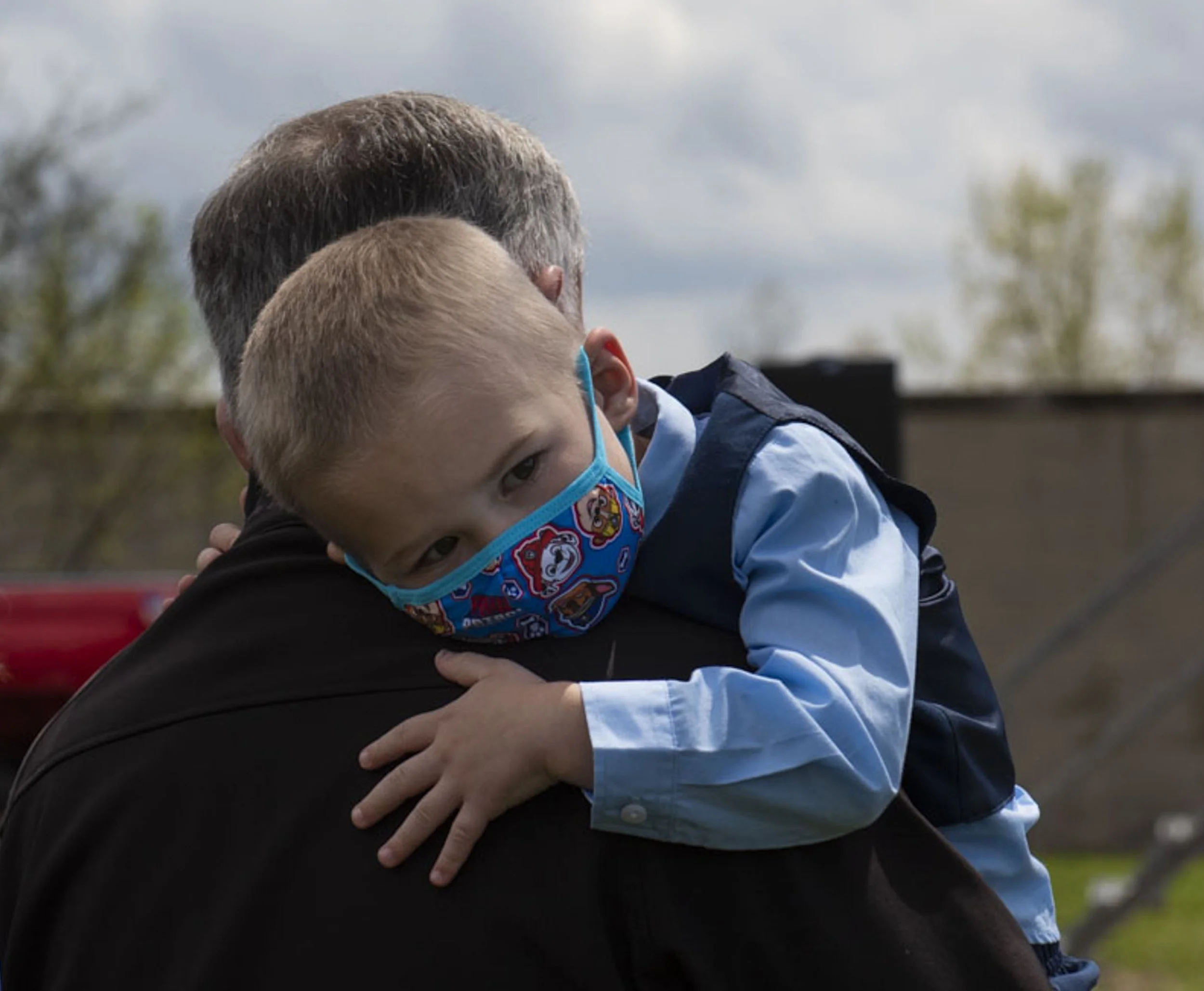  Daniel Sidelinger, 3, clutches to the shoulder of his grandfather, Craig, at a ceremony dedicating two portable training centers in honor of Daniel’s father, Craig Sidelinger, in Ann Arbor, Mich., on Friday, May 7, 2021. Sidelinger was a training of