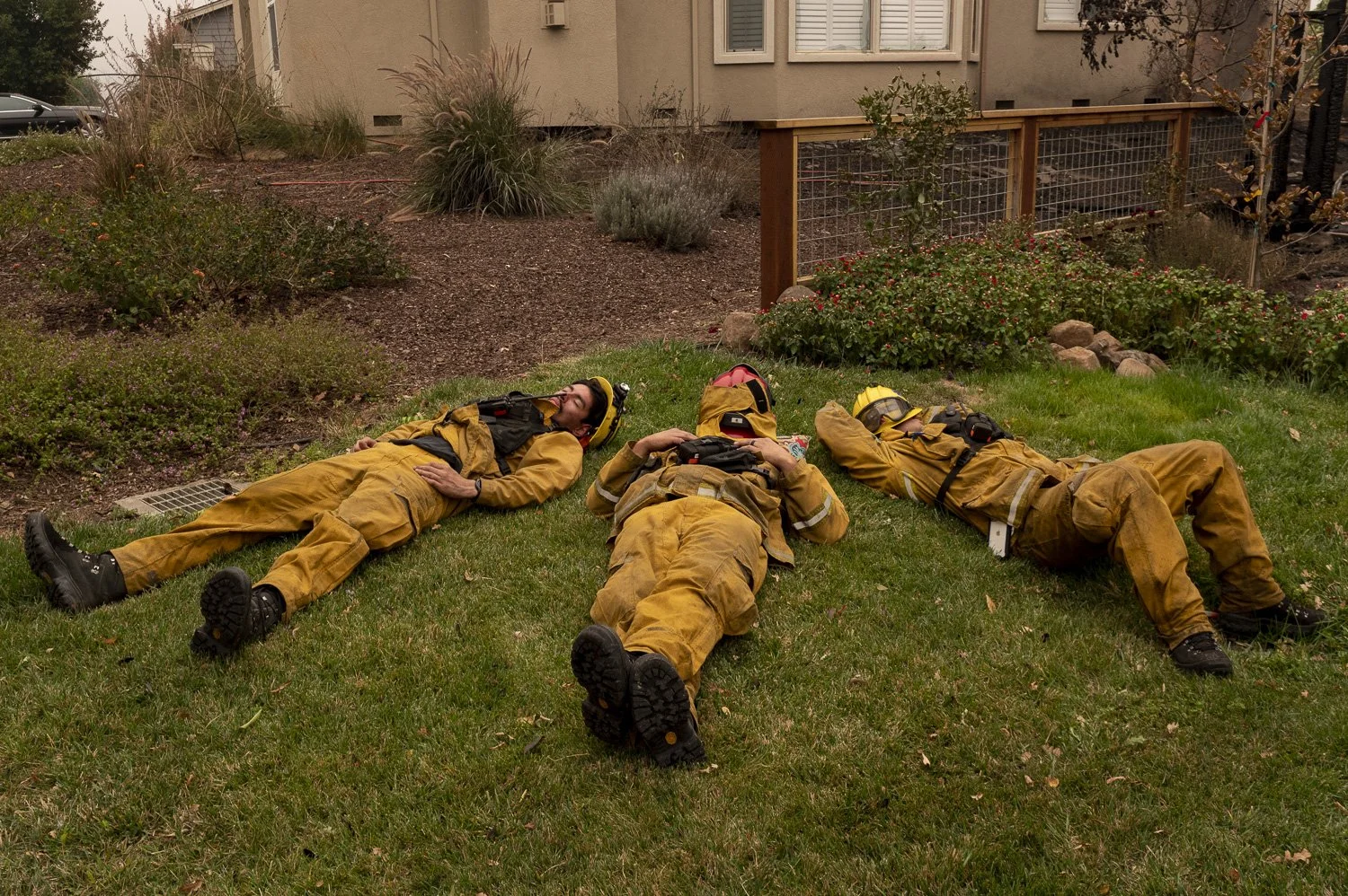  Firefighters take a short rest after protecting homes from the Glass Fire aftermath in Santa Rosa, Calif., on Monday, Sept. 28, 2020. They arrived on the scene at 7 PM last night. “The ground is our bed,” said one of them. 