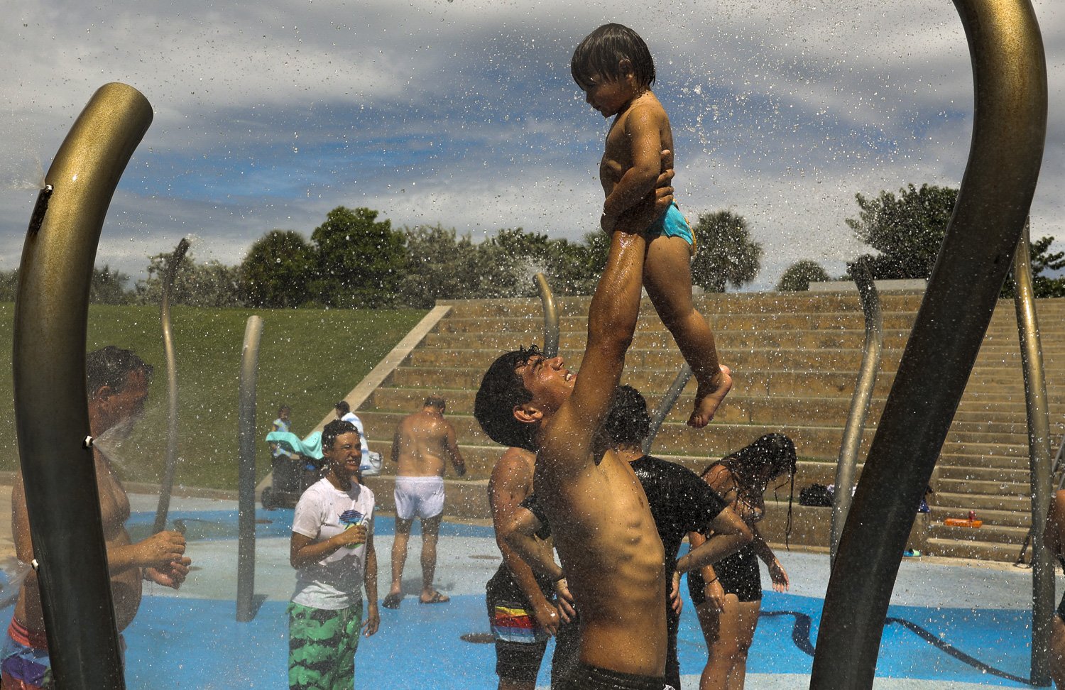  Camille Ecker, left, from France, lifts his little brother   Lucien up in the fountains to cool off after spending time at the beach on Sunday, Aug. 28, 2022, at South Pointe Park. The family is visiting from France and needed to cool off. 2022 was 