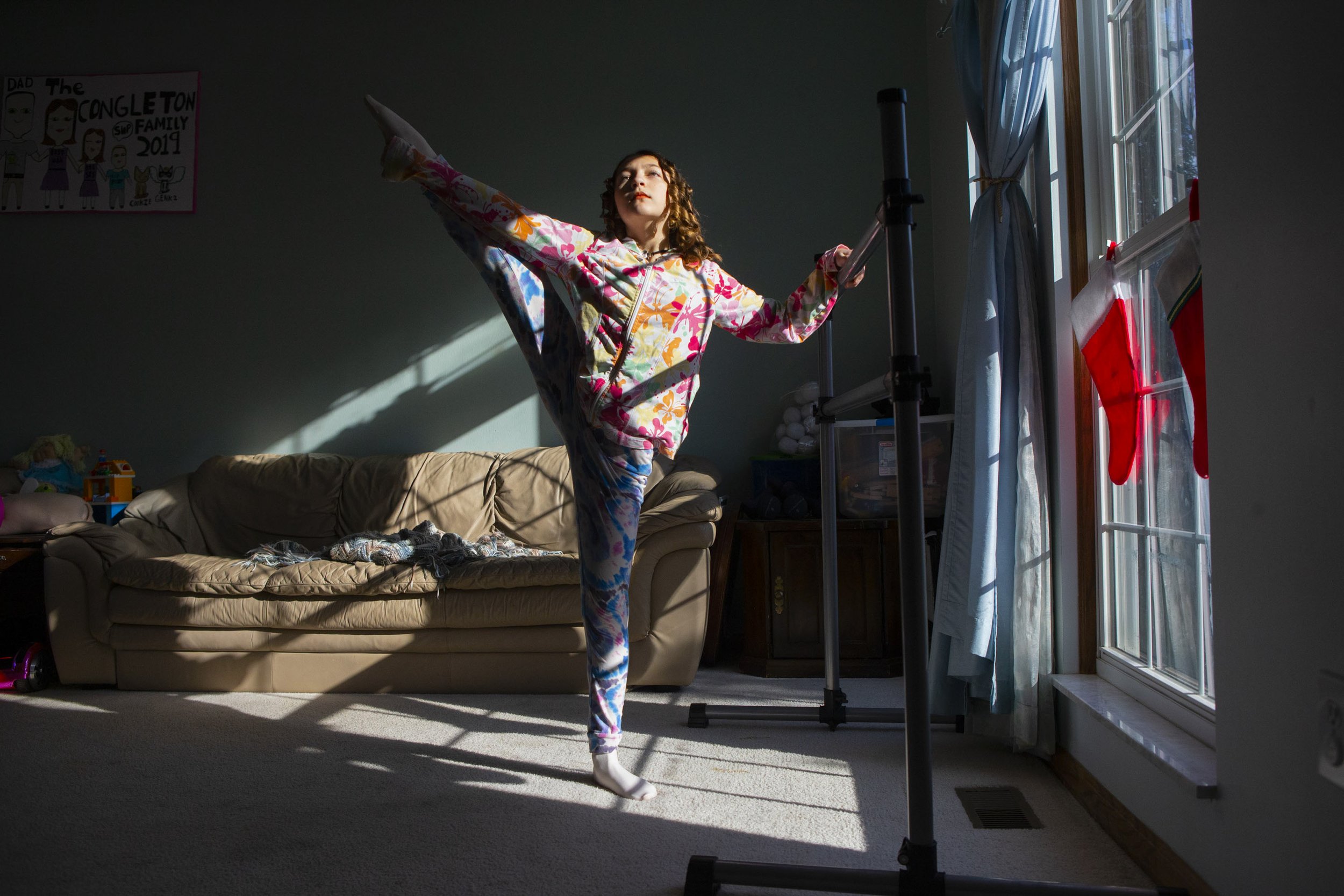 Phoebe Congleton, 12, stretches before ballet practice in her living room in London, Ohio, on Wednesday, Dec. 8, 2021. Congleton is a back up Clara in BalletMet’s production of the Nutcracker this year. All participants in the Nutcracker had to be 12