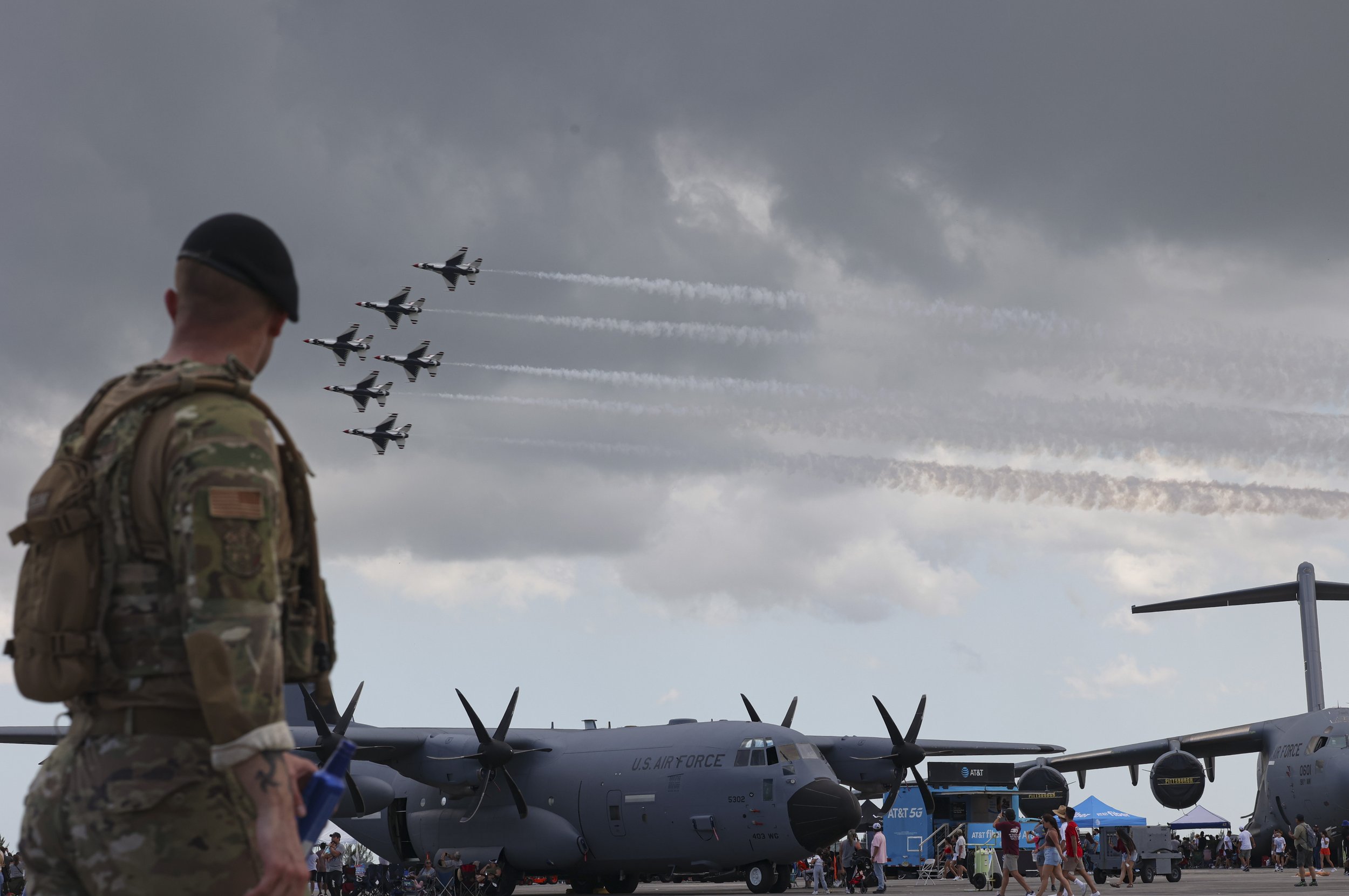 A soldier watches the Thunderbirds perform a demonstration during the Wings Over Homestead Air Show on Sunday, April 2, 2023, at the Homestead Air Reserve Base in Homestead, Fla. The Thunderbirds are the air demonstration squadron of the United State