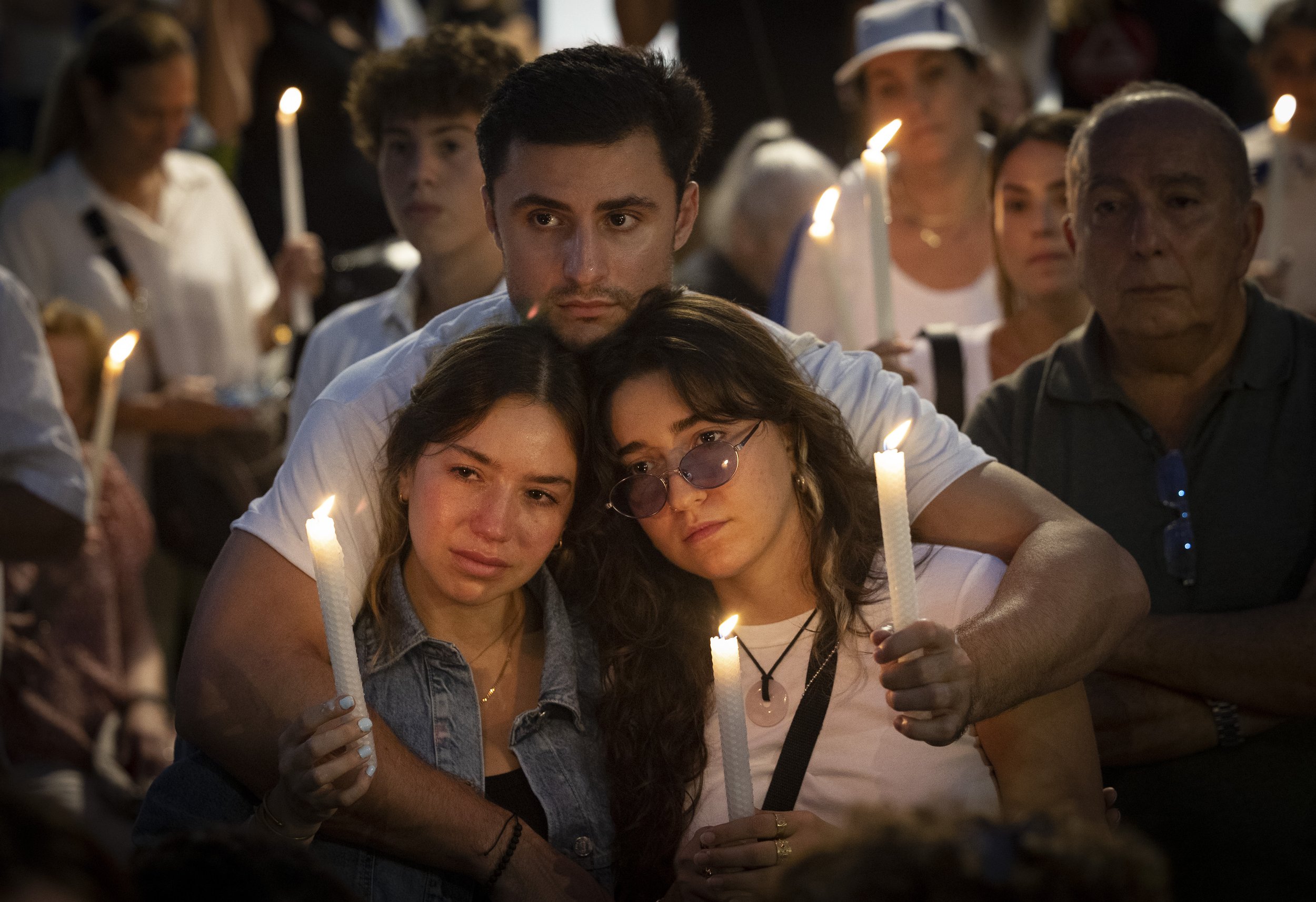 Isabella Green, left, and her sister, Nikita, share an embrace with Isaac Manton during a rally in support of the Israeli people in the Israel-Hamas conflict on Monday, Oct. 9, 2023, at Waterways Shoppes in Aventura, Fla. Miami has a large population