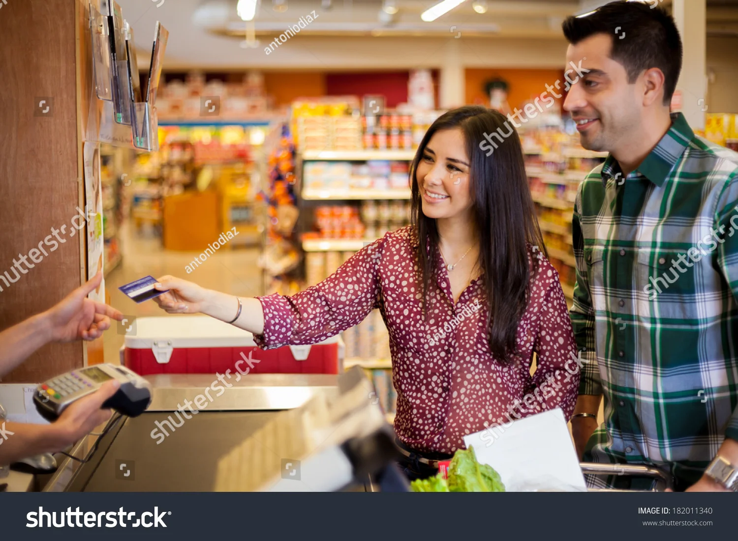 stock-photo-beautiful-young-brunette-and-her-boyfriend-buying-some-groceries-at-the-supermarket-and-paying-with-182011340.jpg