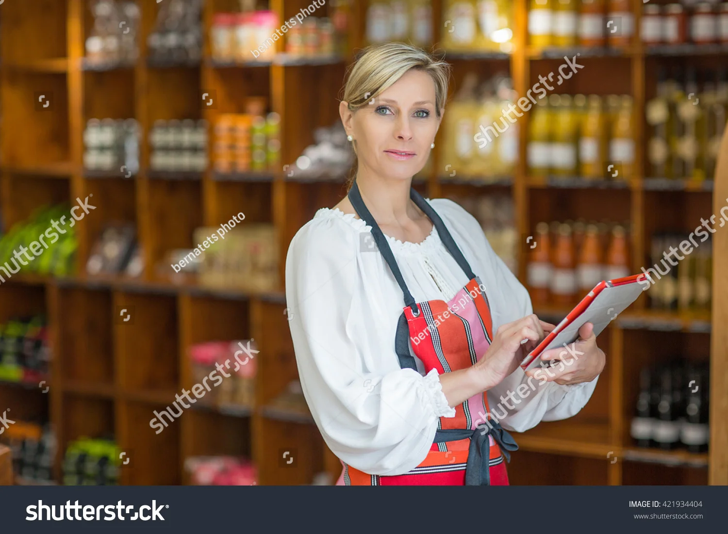 stock-photo-woman-holding-digital-tablet-in-grocery-store-421934404.jpg