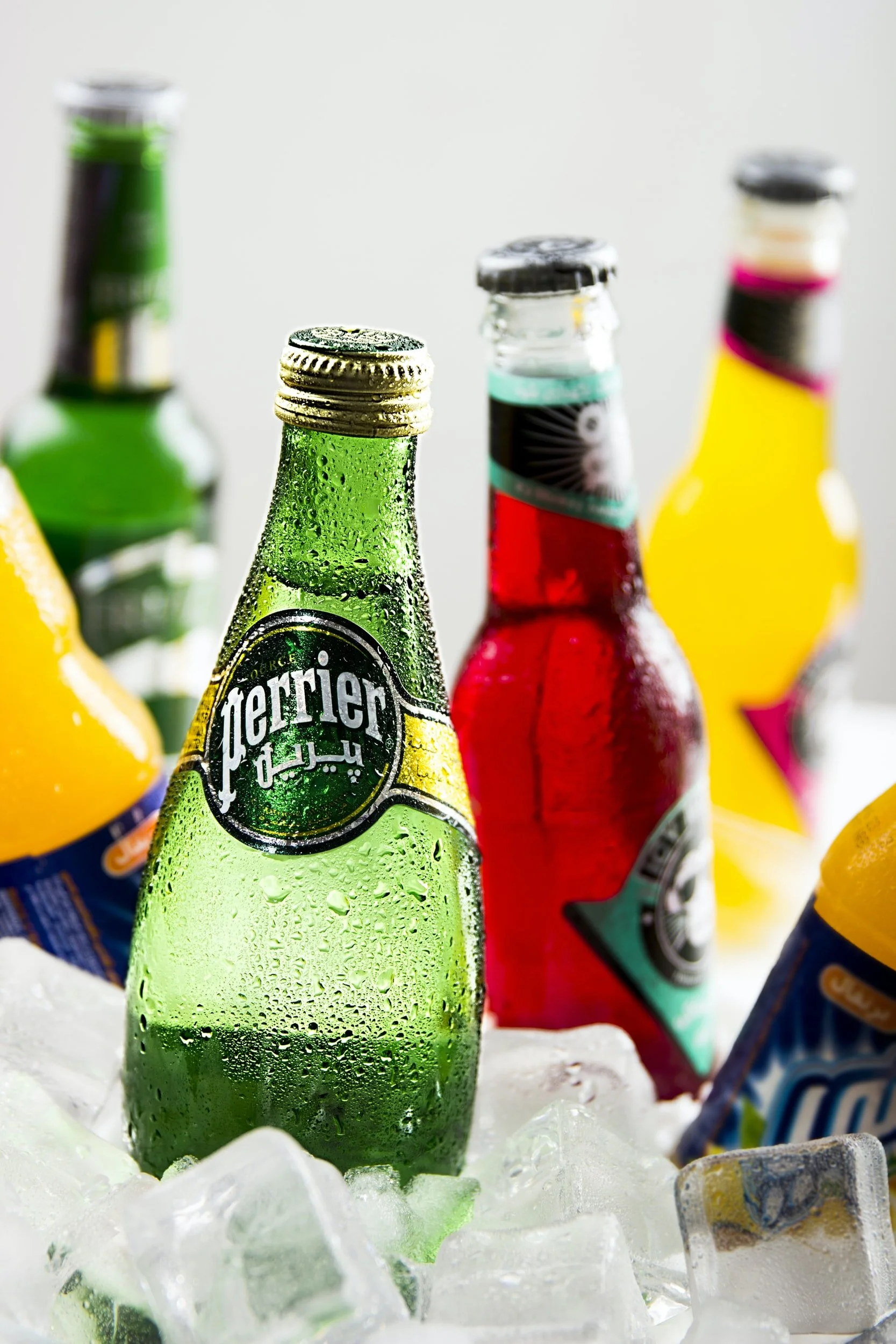 Bottle of Perrier and other soft drinks on ice