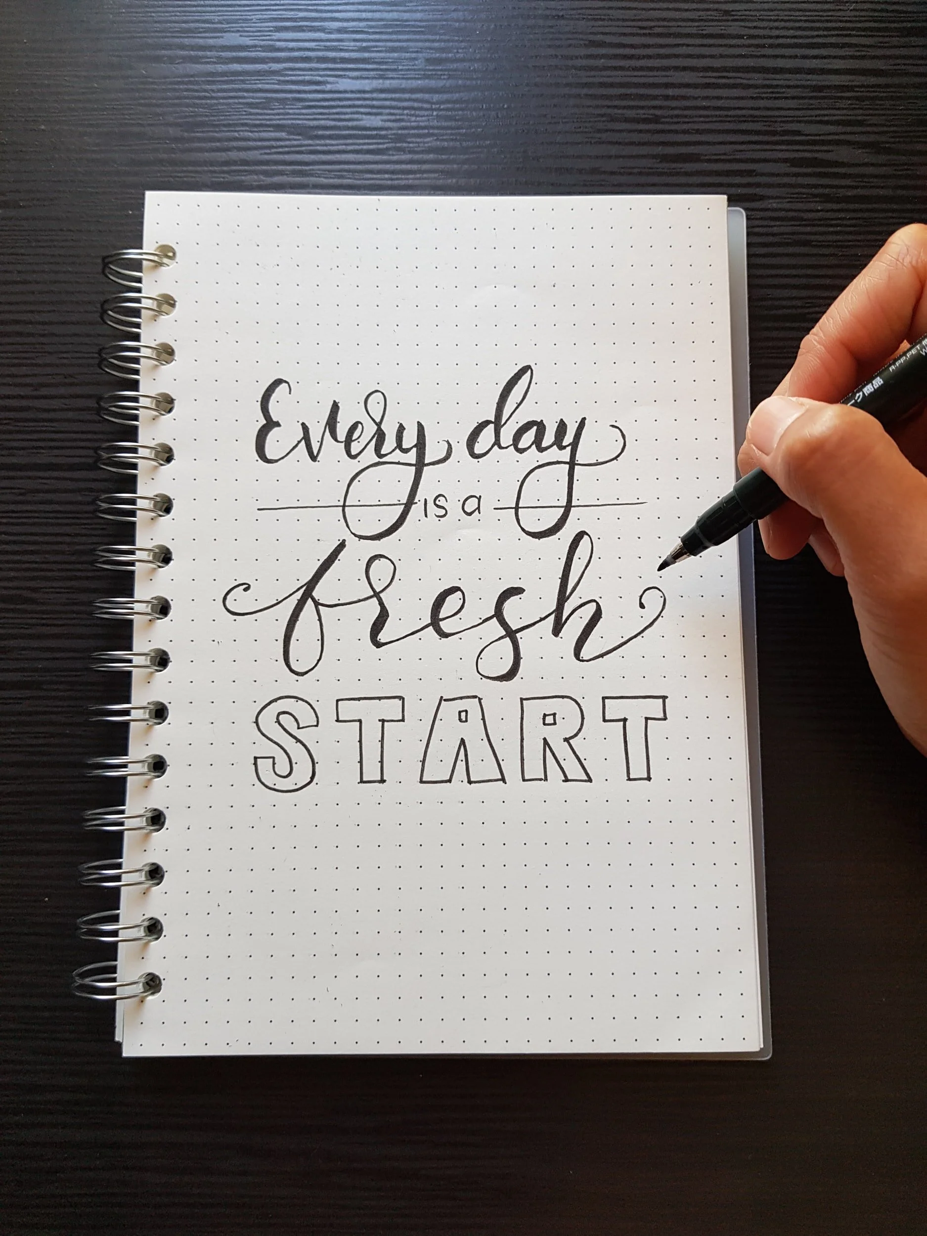 "Every day is a fresh start" artfully written in on a journal page