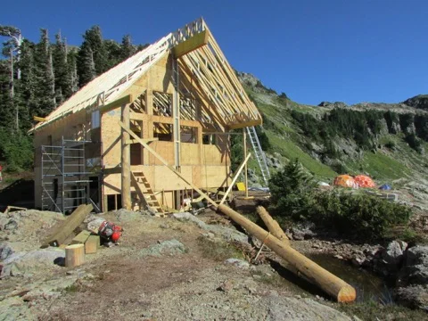 The roof trusses are nearly all in place. The large yellow cedar columns were donated by partnering First Nations, and will stand in front. The left hand one is already in place.