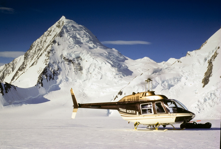 Trans North helicopter at our base camp location 2620m on the glacier below Pinnacle Peak. Best view of our ski route to the low point on the W col and the entire W ridge (right skyline). Photo by Roger Wallis. 