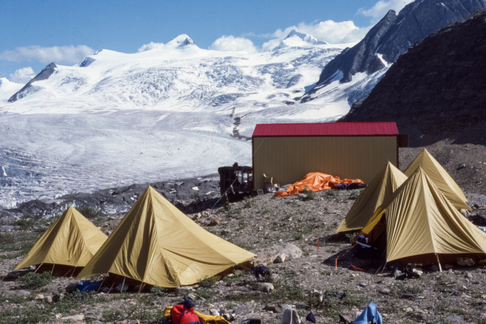  The Lloyd McKay Hut (as it was in 1986) and those camped outside. On the far skyline from the left to right: at the very edge of the photo is “Far West” Barlow; Gilgit, and then the high snow plateau with first Nanga Parbat; then on the right - Trut