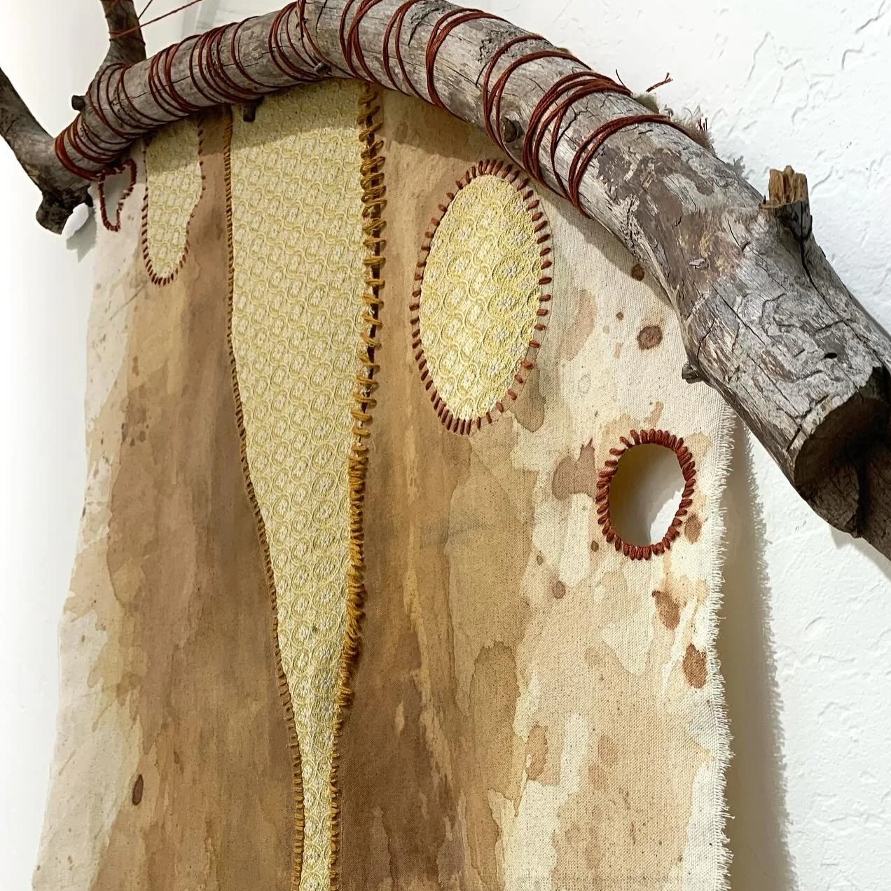 canvas hanging from a ponderosa pine branch. Insets of vintage fabric and hand-stitched details depicting the canyon.