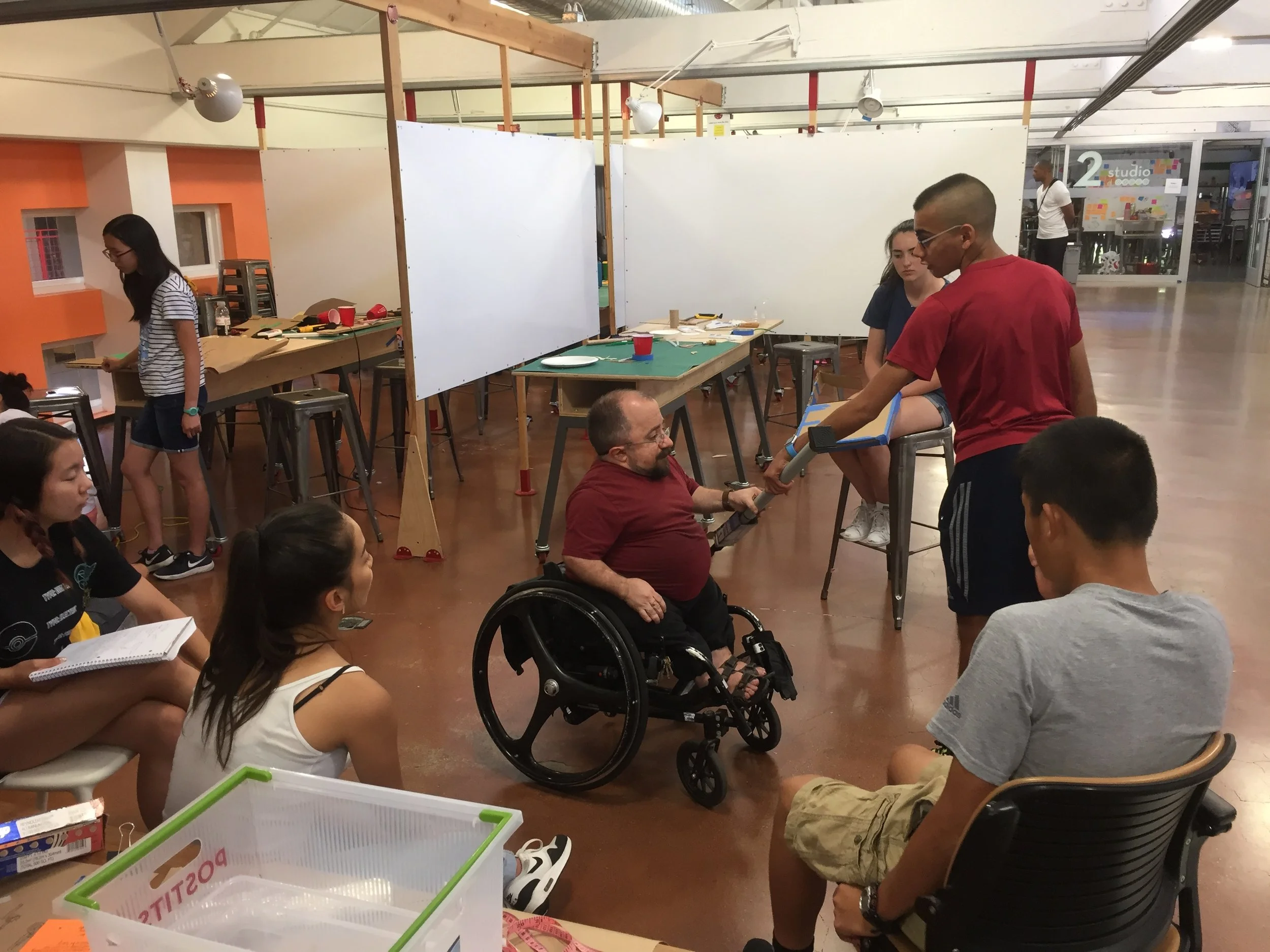 Man in wheelchair greets students